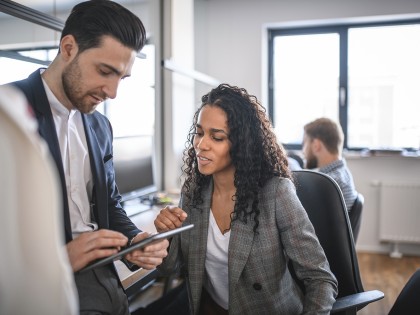 Twee medewerkers kijken samen naar tablet