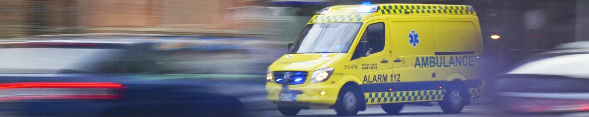 Ambulance driving fast through traffic