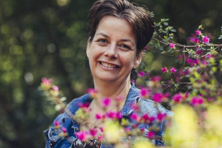 Miriam, van Veerkracht bij kanker, in een bloemige struik