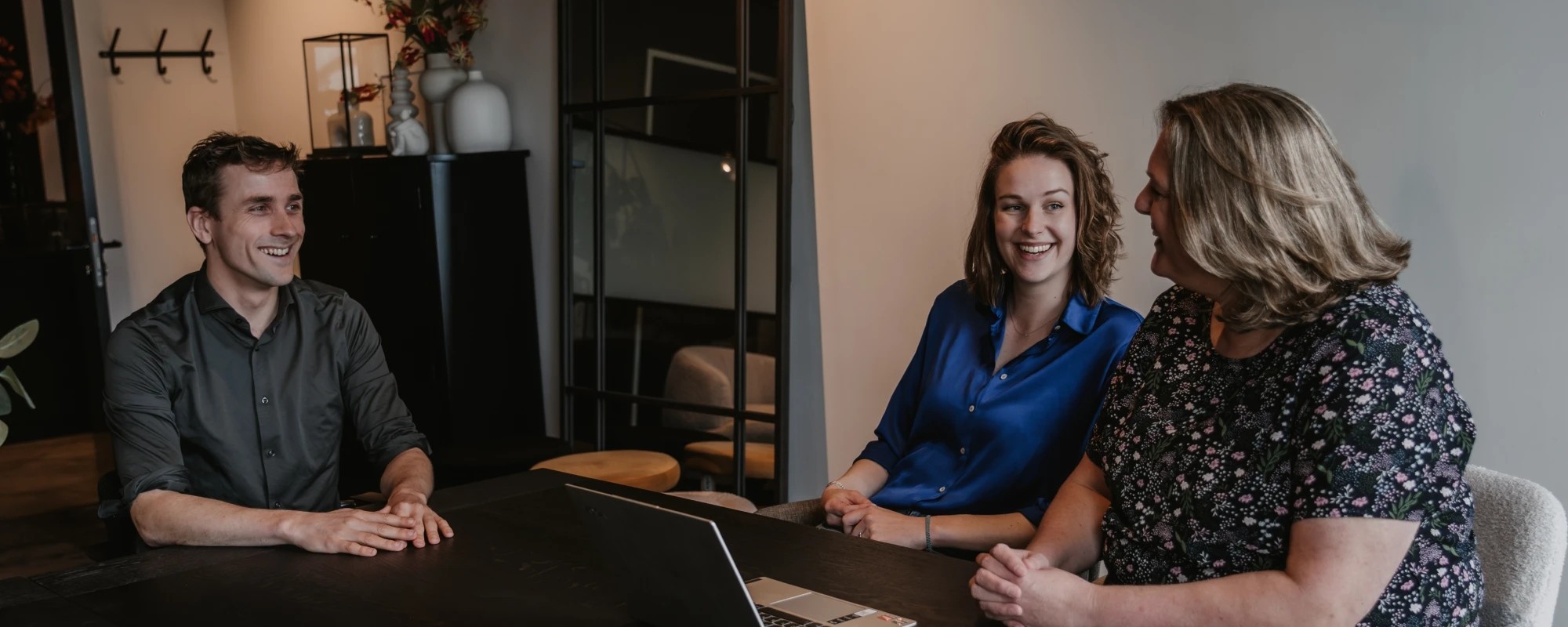 Ryanne aan tafel met twee klanten tijdens een vergadering over de quickscan