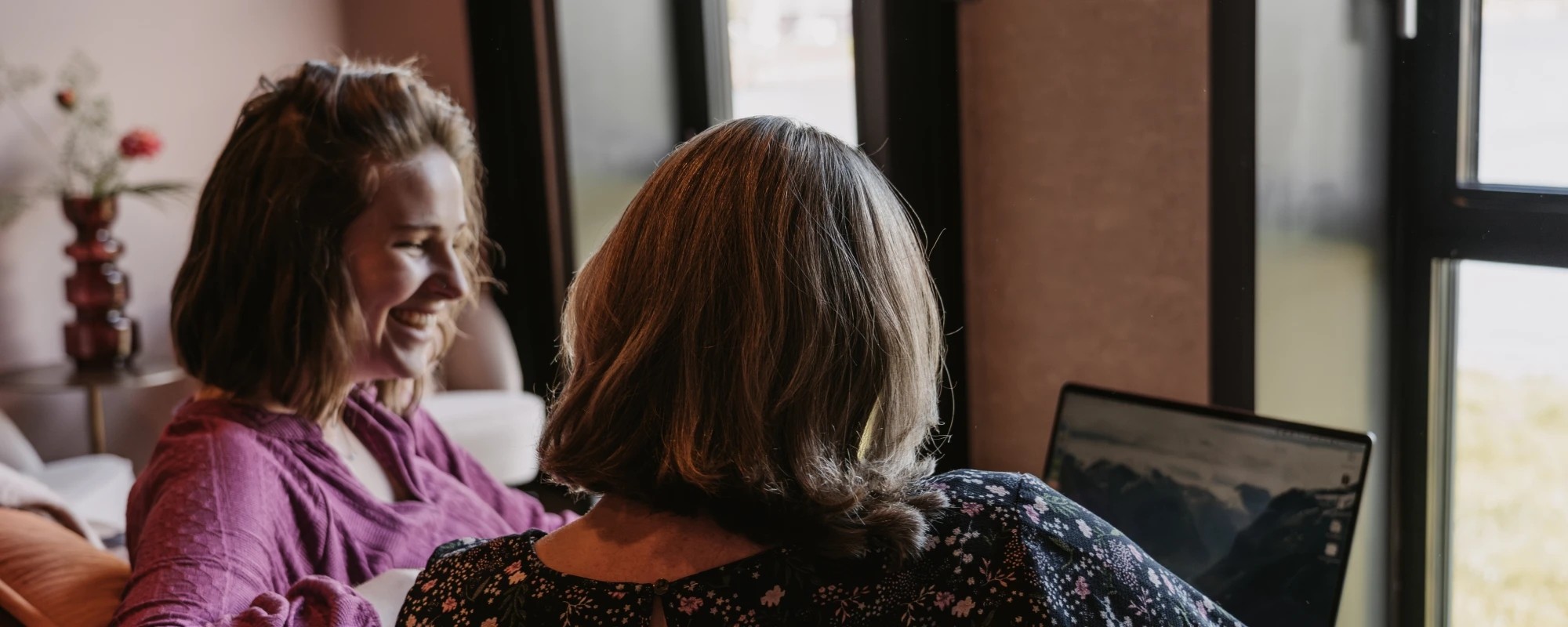 Ryanne bespreekt contentonderzoek met een klant, kijkend naar een laptop