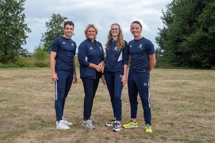 Vier werknemers van sportadviesgroep staan op een grasveld