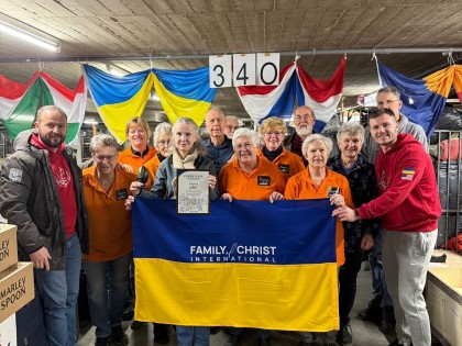 Foto 1.   Rudolf Balazynets (links op de foto) met de Skin vrijwilligers en de Oekraiense vlag.  Hilde Eleveld houdt een dankbetuiging vast.IMG-20250115-WA0004