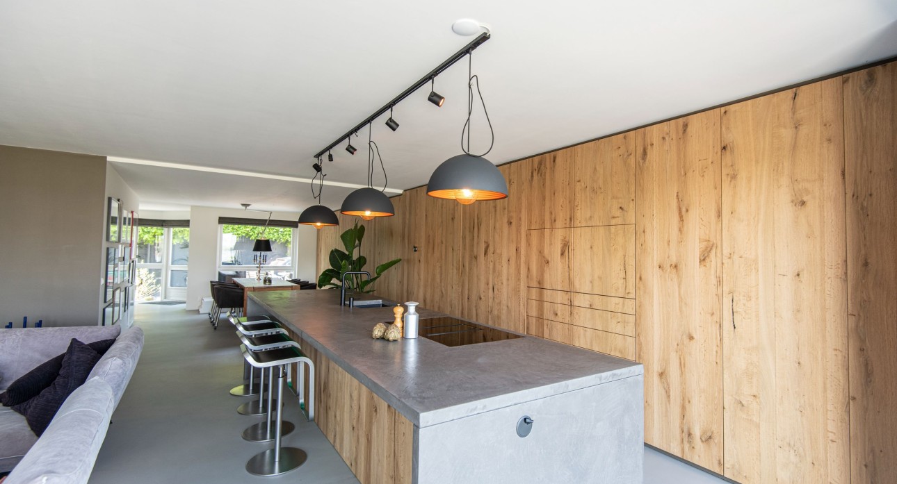 Luxe landelijke keuken van eikenfineer en  met kookeiland en kookplaat met afzuiging