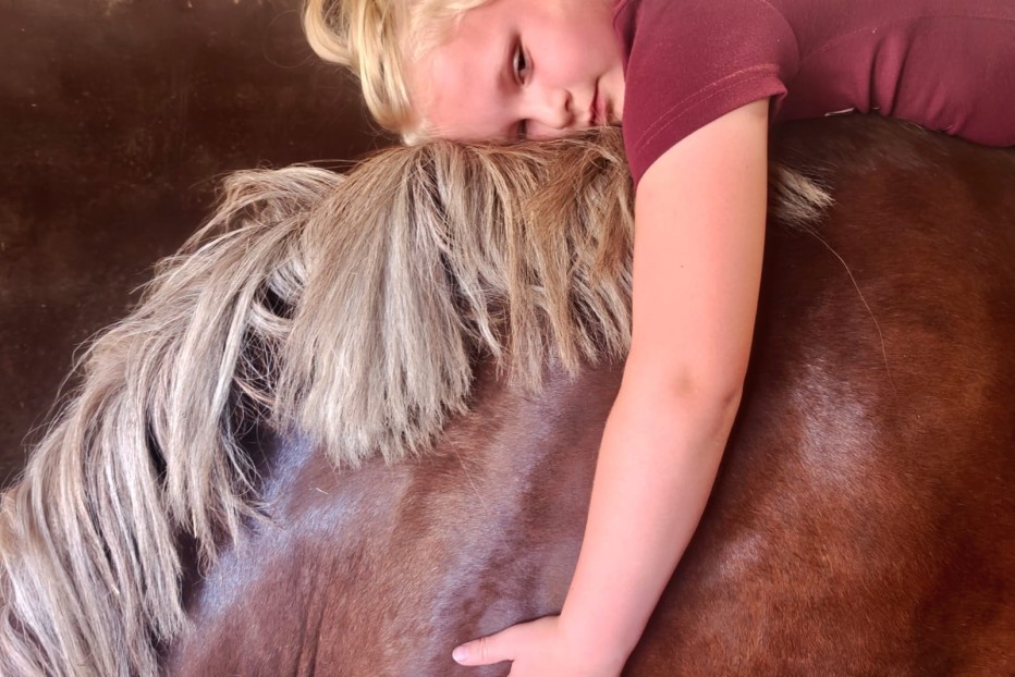 kindje geeft zich volledig over aan het paard