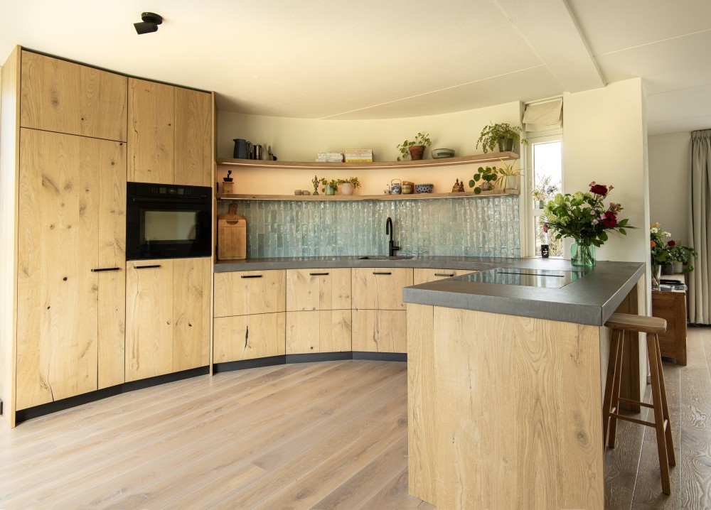 Keuken gebouwd tegen een kwart ronde wand glooiend met de vorm van de muur