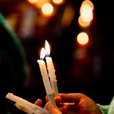 Vrijwilligers reiken de aansteekkaarsen aan