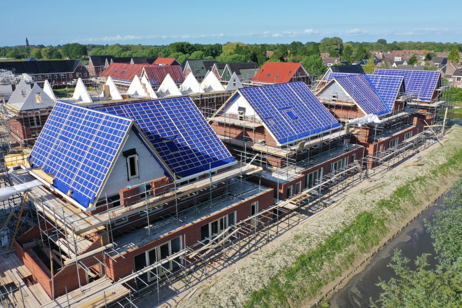 Nieuwbouw woningen in de steigers in aanbouw. Metselwerk, schanierkappen  en pannelatten zichtbaar